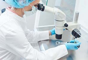 a scientist is looking through a microscope in a laboratory .