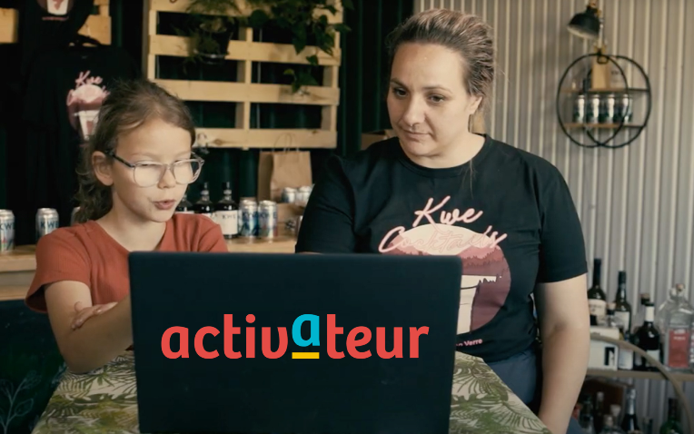 Image d'une femme et d'un enfant regardant un ordinateur portable sur lequel est écrit 