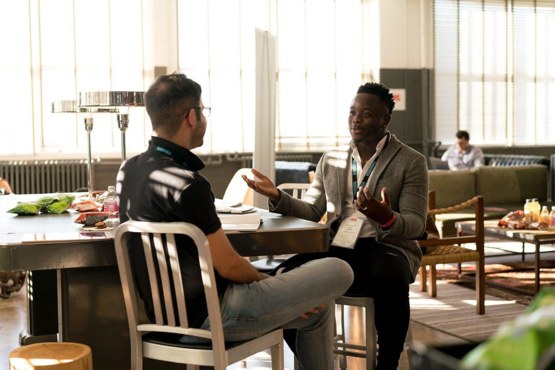 Deux hommes assis à une table en discussion.