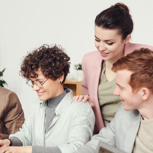 Image d'un groupe de personnes assises autour d'une table et regardant un écran d'ordinateur.
