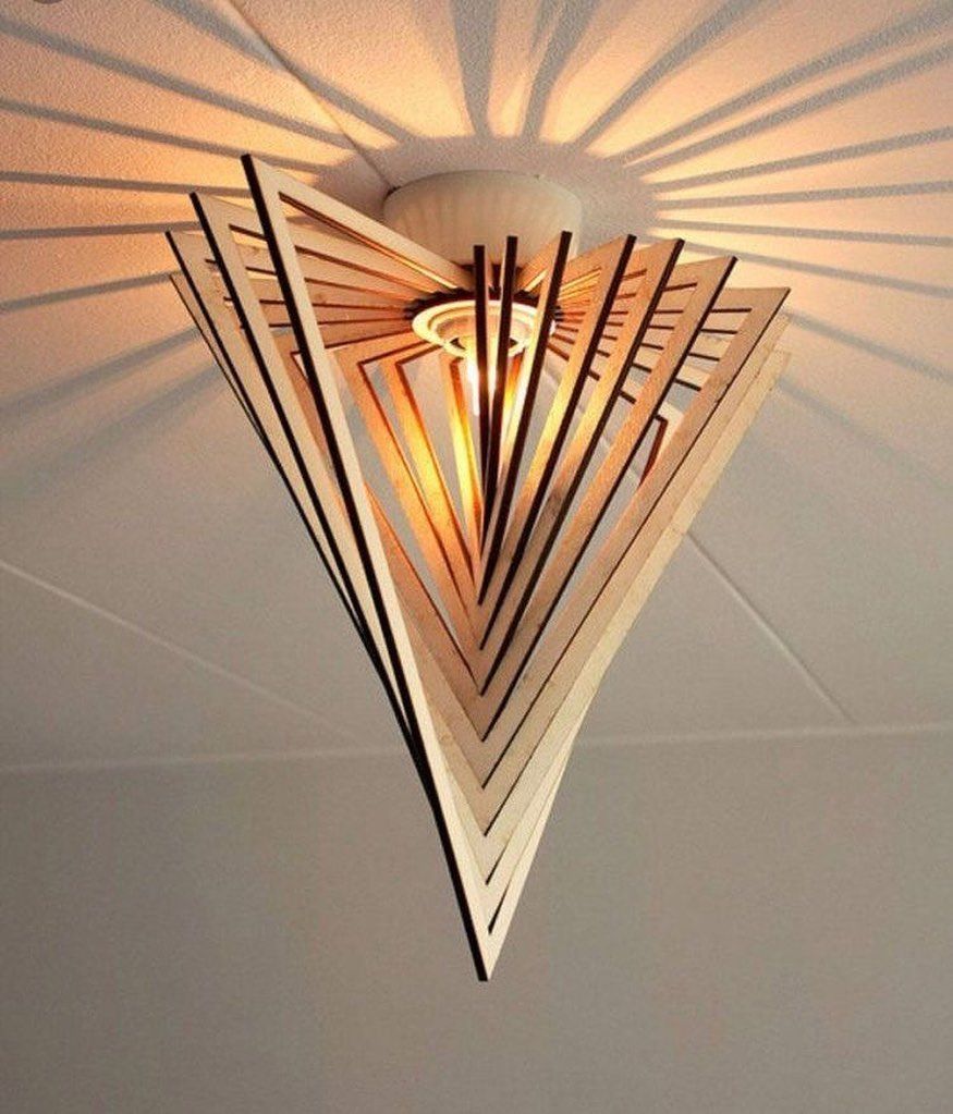 Geometric pendant light with layered triangular metal panels and warm glow on a ceiling