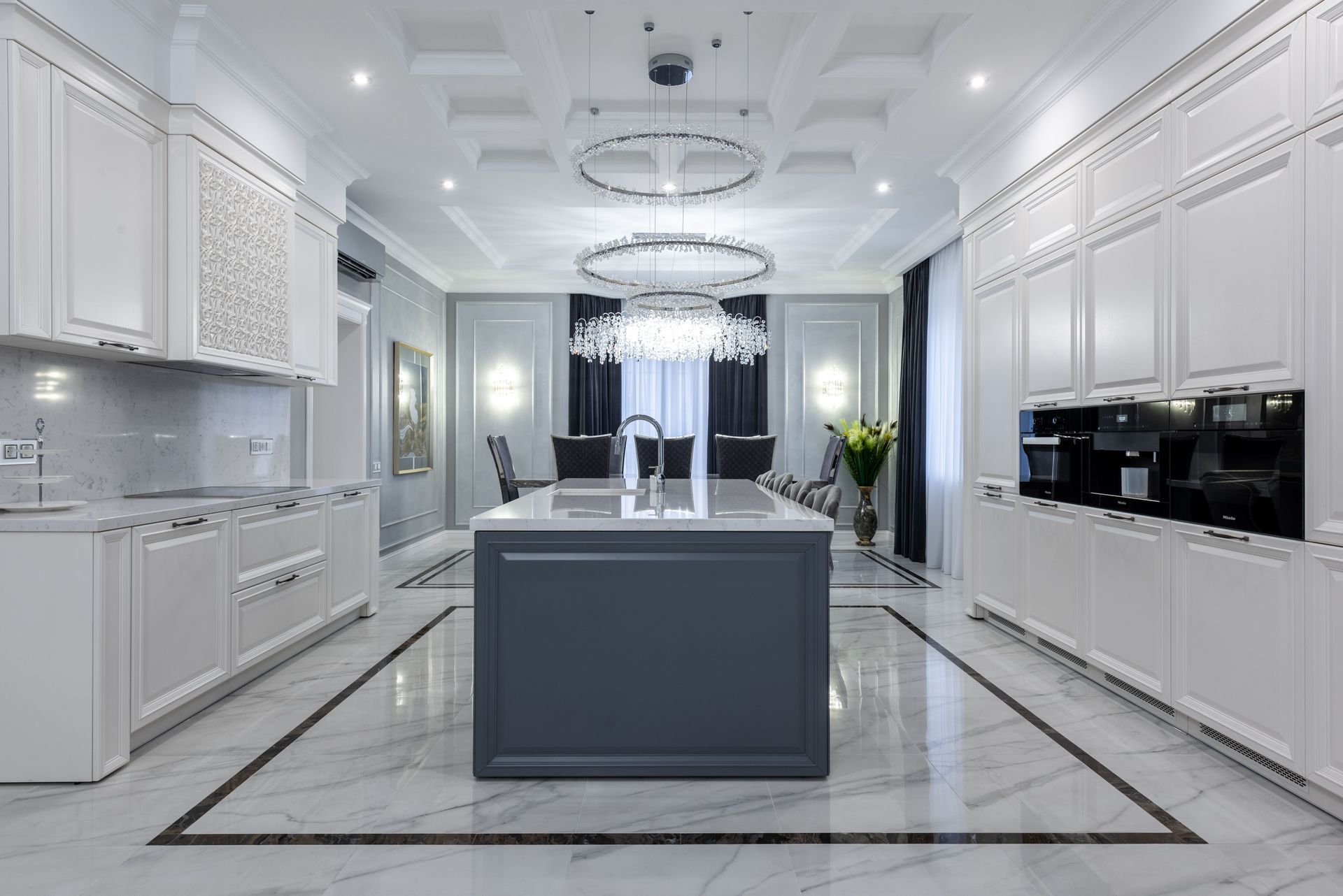 Modern white kitchen with marble floors and a gray island centerpiece