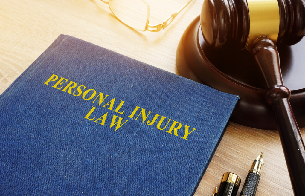 Personal injury law book beside a judge’s gavel on a desk