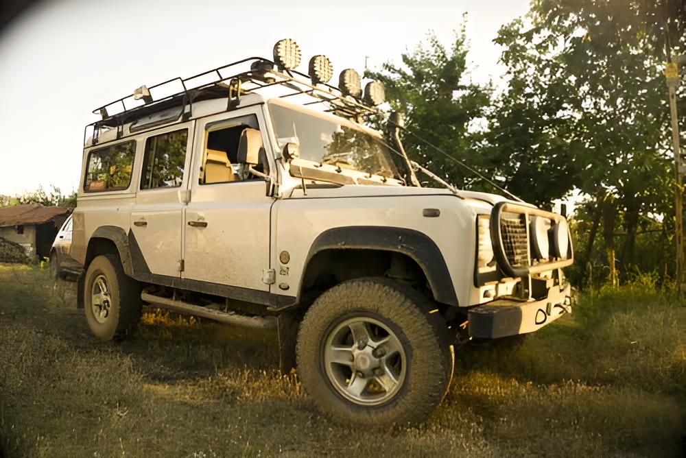 A White Land Rover is Parked in a Field With Trees in the Background — Land Rover Spares In Mackay, QLD