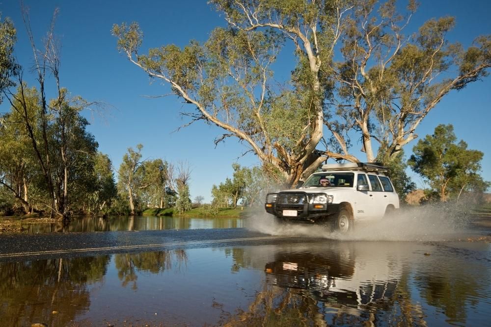 A White Suv is Driving Through a Flooded Road — Land Rover Spares In Mackay, QLD