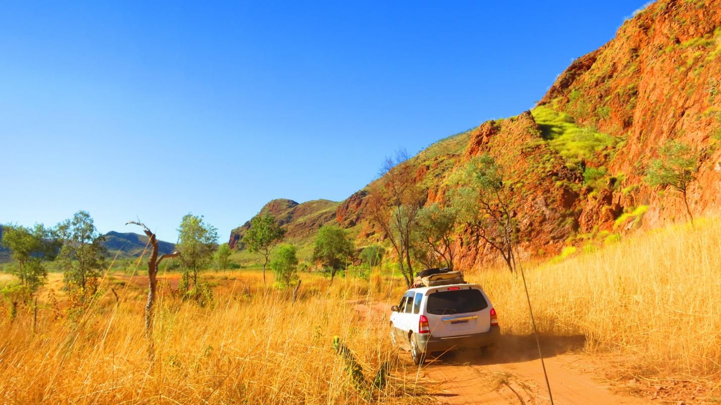 A White Suv is Driving Down a Dirt Road in the Desert — Land Rover Spares In Mackay, QLD