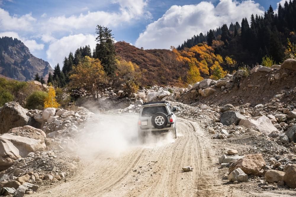 A Car is Driving Down a Dirt Road in the Mountains — Land Rover Spares In Mackay, QLD