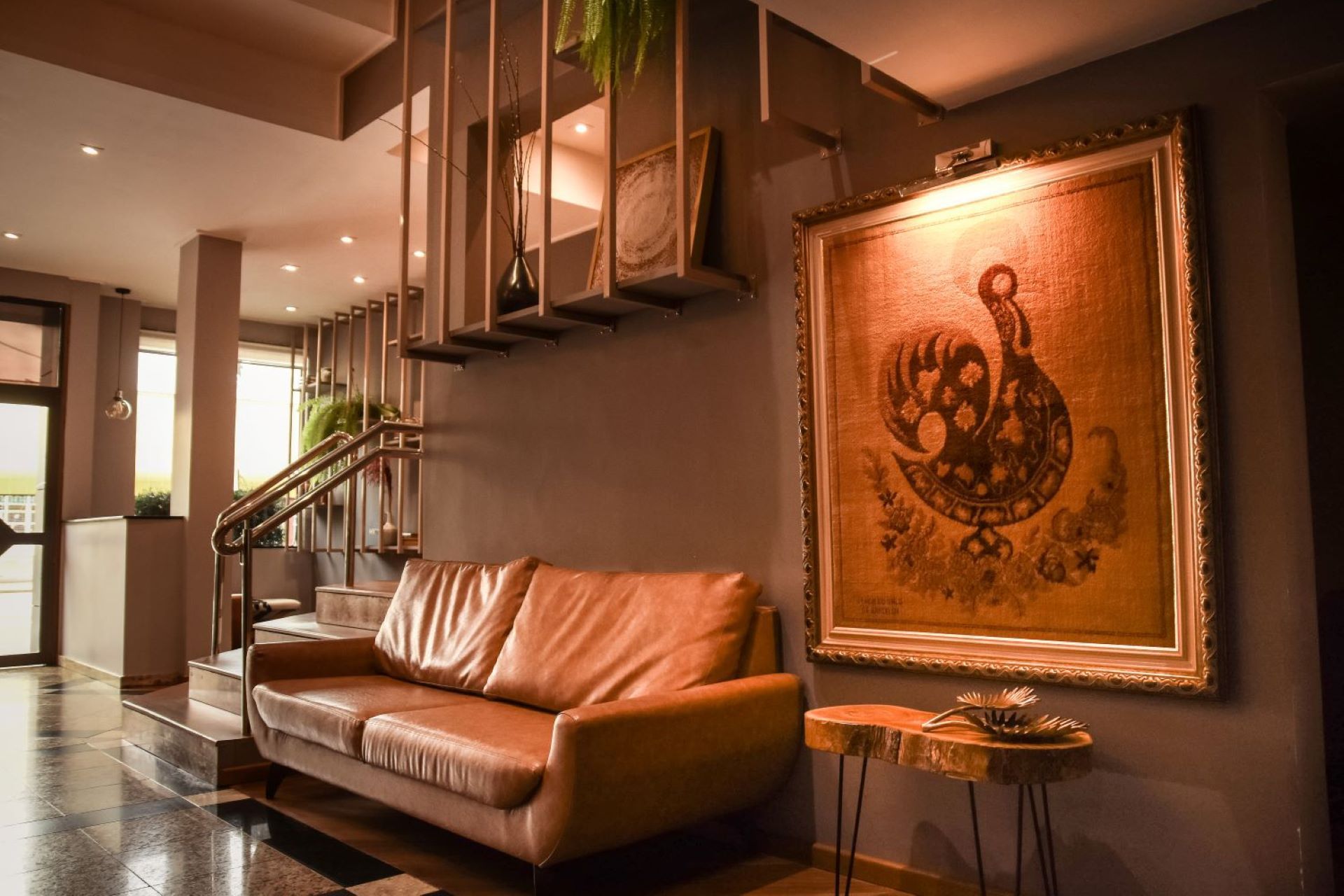 Uma sala de estar com um sofá e uma pintura na parede.