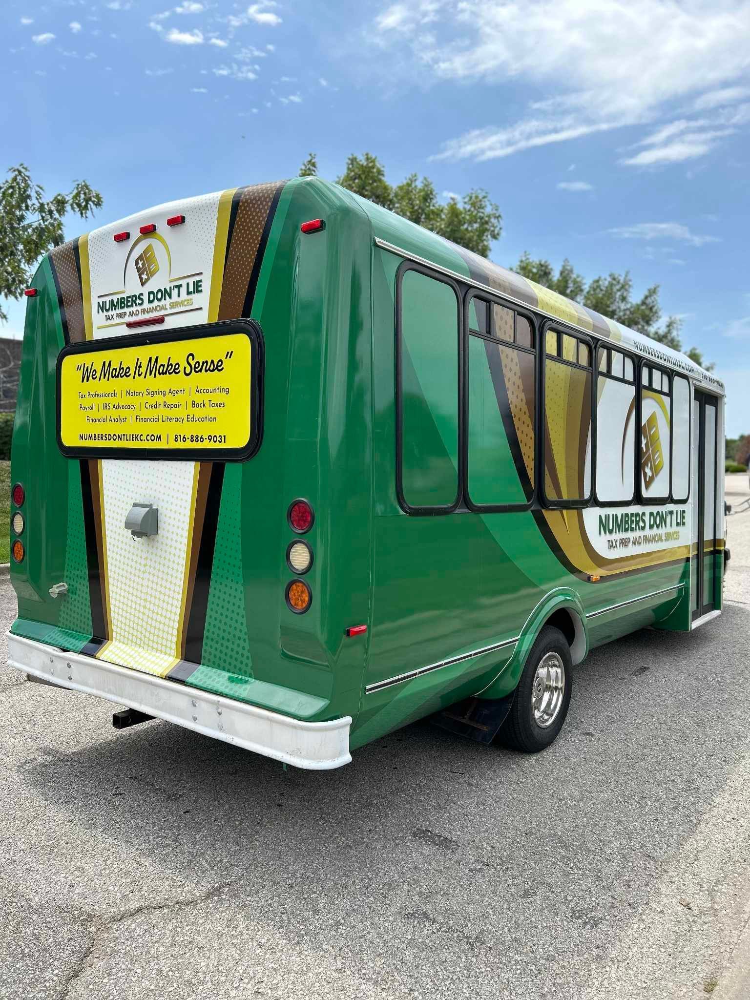 A green food truck is parked on the side of the road.
