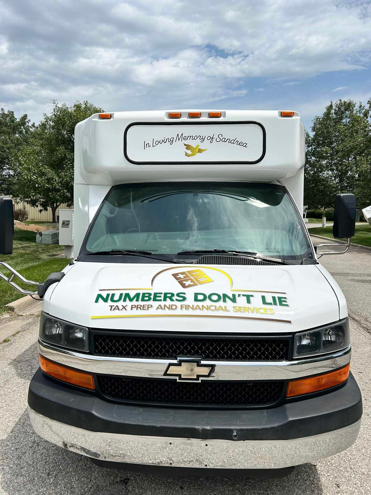 A white van with the words `` numbers don 't lie '' on the front is parked in a parking lot.