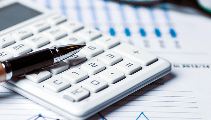 A pen is sitting on top of a white calculator.