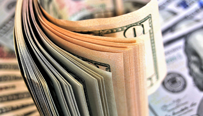 A stack of money is sitting on top of a pile of money.