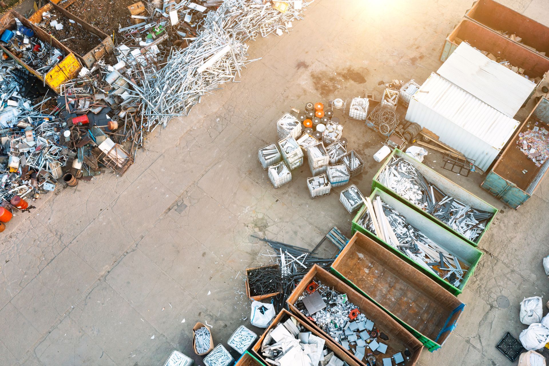 Aerial view of a scrap yard with metal piles, roll-off dumpsters, and bulk bags of materials Aerial view of a scrap yard with metal piles, roll-off dumpsters, and bulk bags of materials
