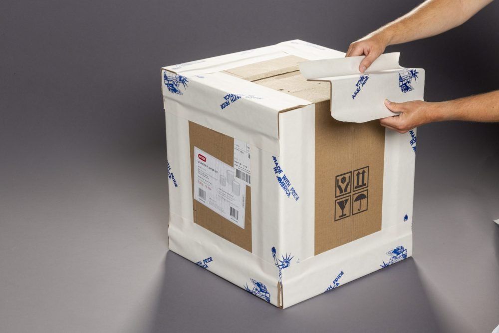 A person is opening a cardboard box with a 3m sticker on it