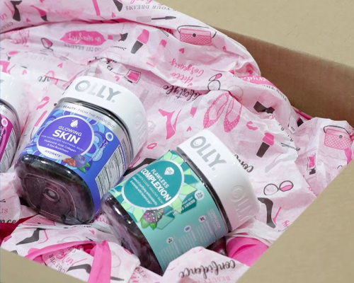 Three bottles of olly vitamins are sitting in a box.