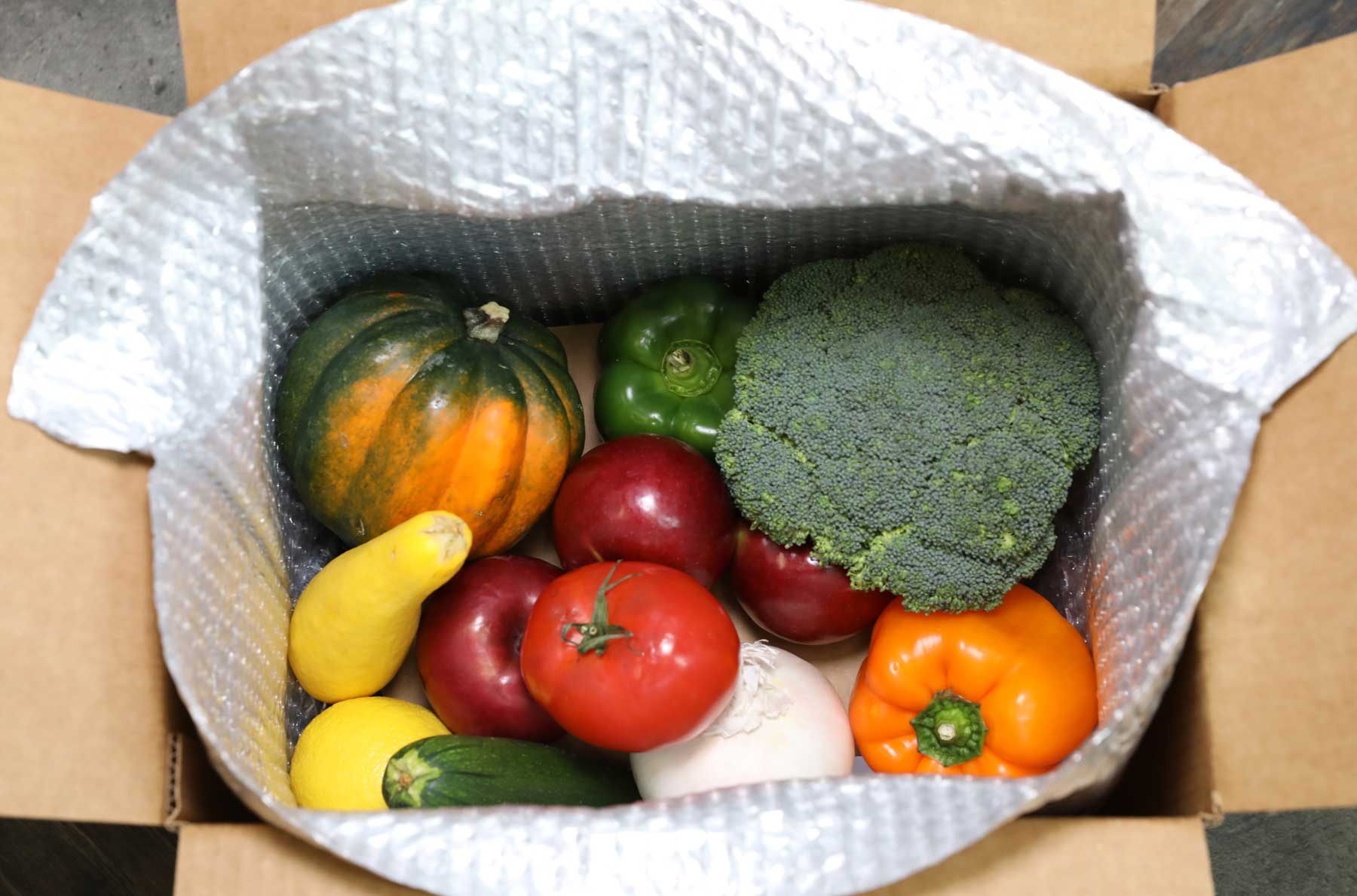 A box filled with vegetables including broccoli and peppers