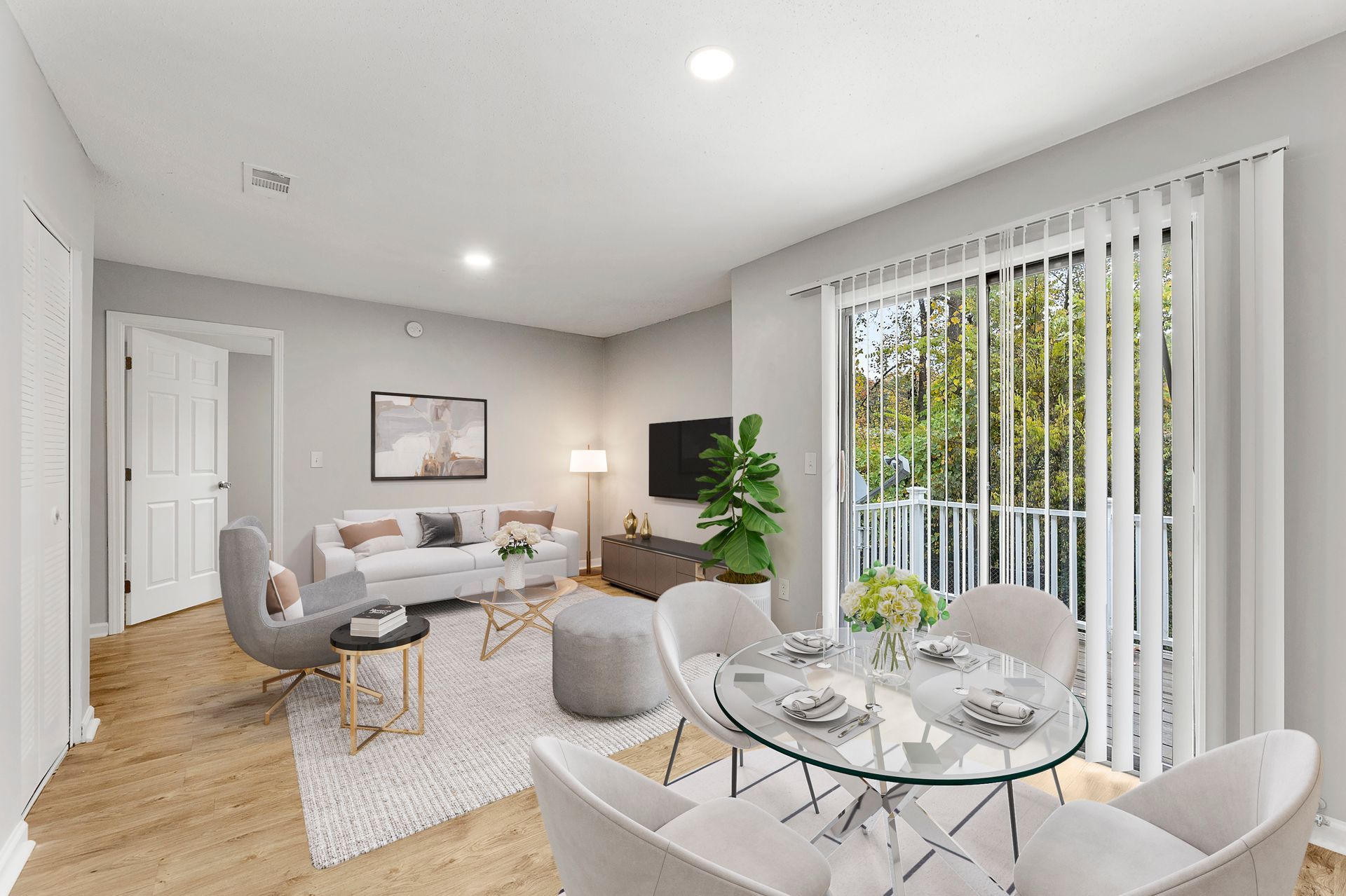 Bright modern living and dining room with sofa, glass table, and large vertical blinds by a window