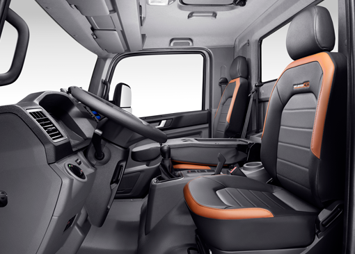 El interior de un camión volkswagen con asientos negros y un volante.