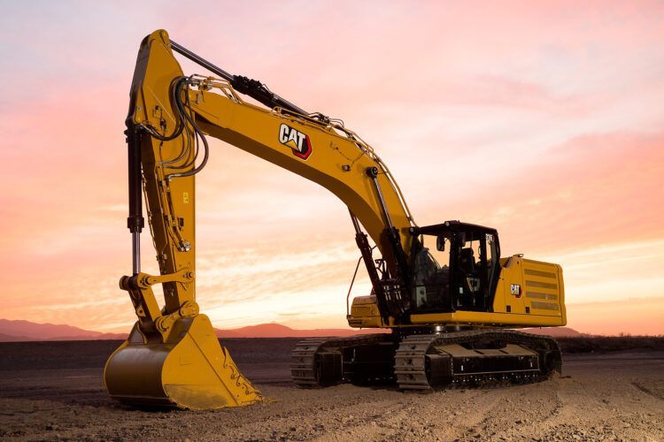 Excavadora amarilla al atardecer en una obra de construcción de tierra.