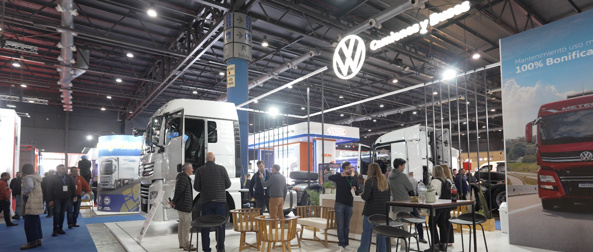 Un grupo de personas se encuentran alrededor de un stand de Volkswagen en una exposición de automóviles.