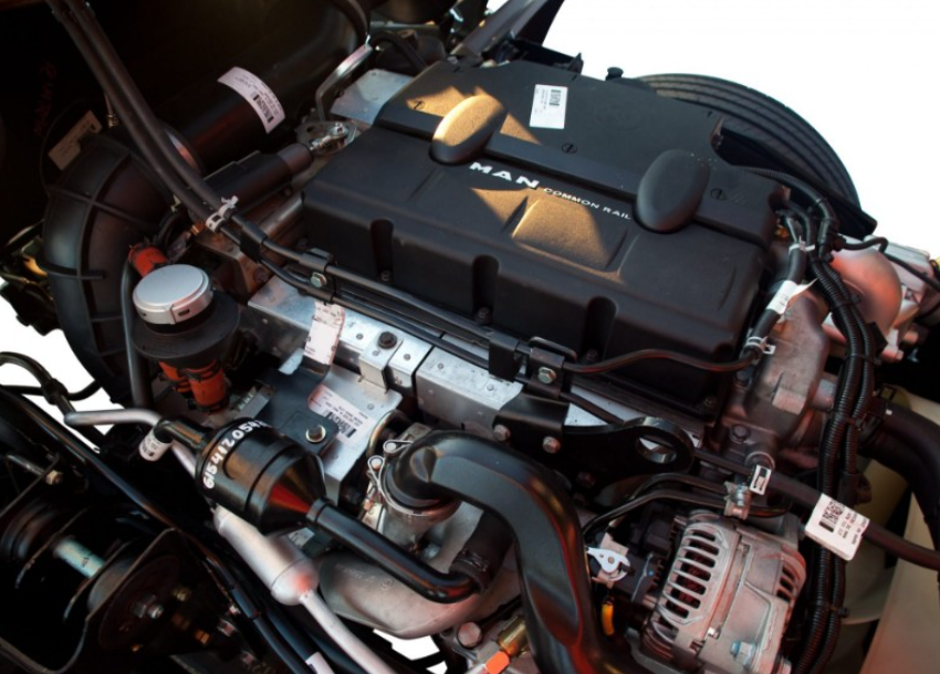 Motor de camión con componentes negros y varios tubos y cables.