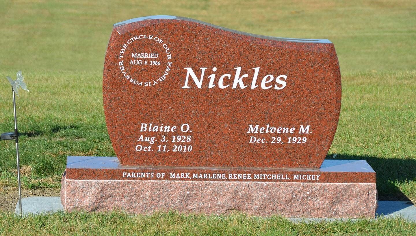 Brown Nickles gravestone in a cemetery with engraved names and dates on a stone base