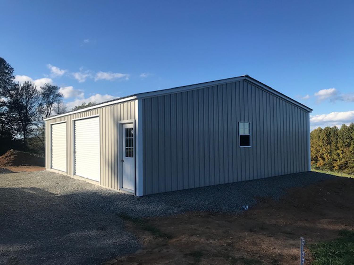 A large metal building with two garage doors and a window.