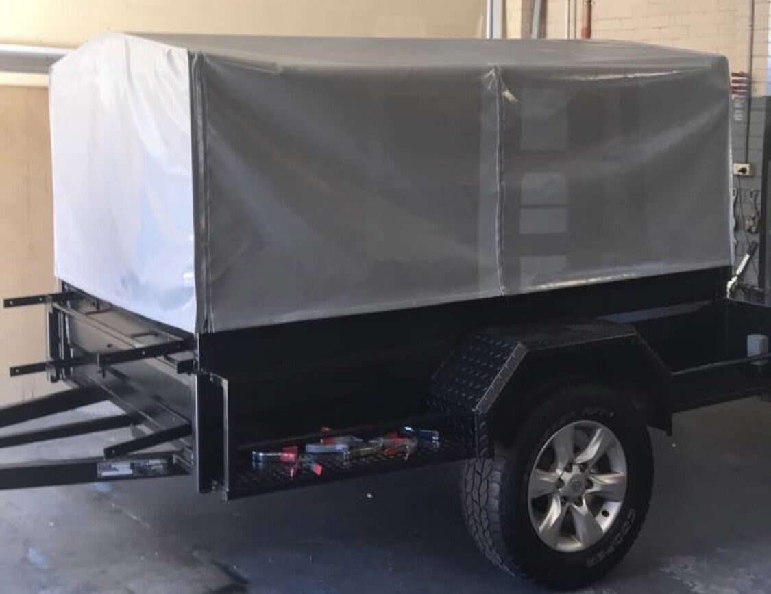A Black Trailer with A White Tarp on Top Is Parked in A Garage - Quality Canvas Products In Illawarra, NSW
