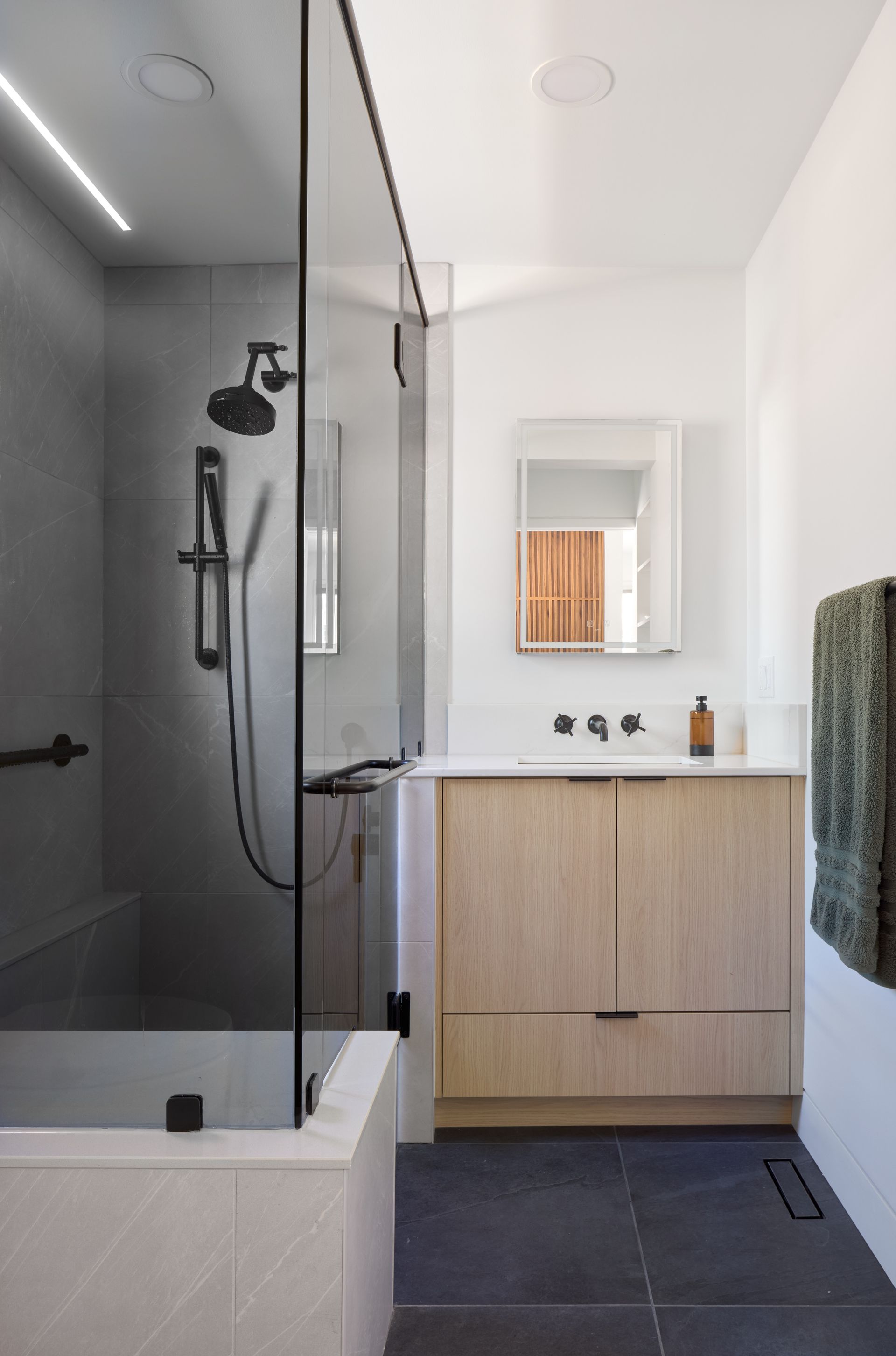 A bathroom with a walk in shower , sink , and mirror.