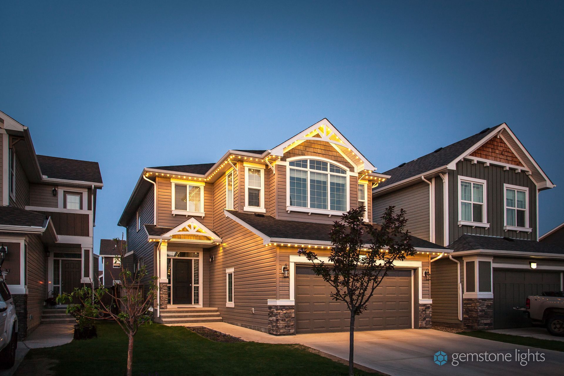 A large house with christmas lights on it is lit up at night.