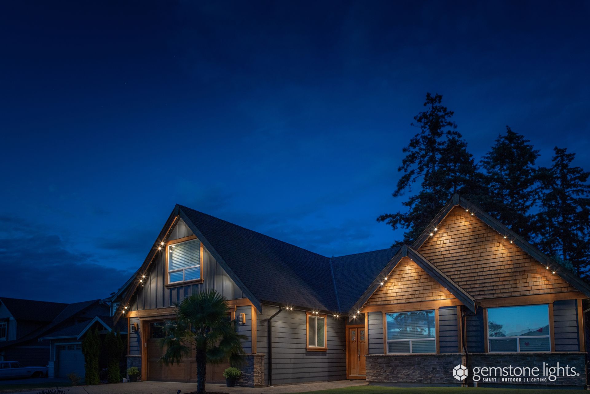 A house with christmas lights on it is lit up at night.