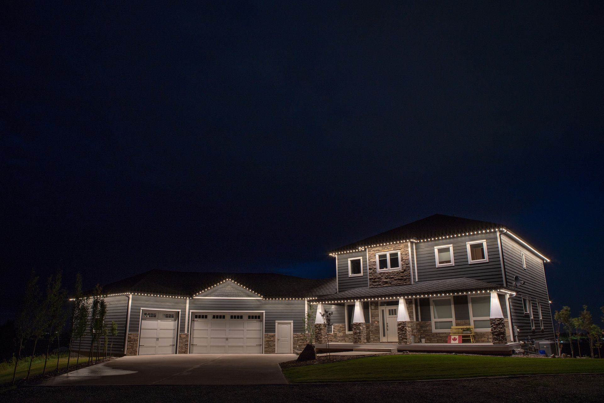 A large house is lit up at night with christmas lights.