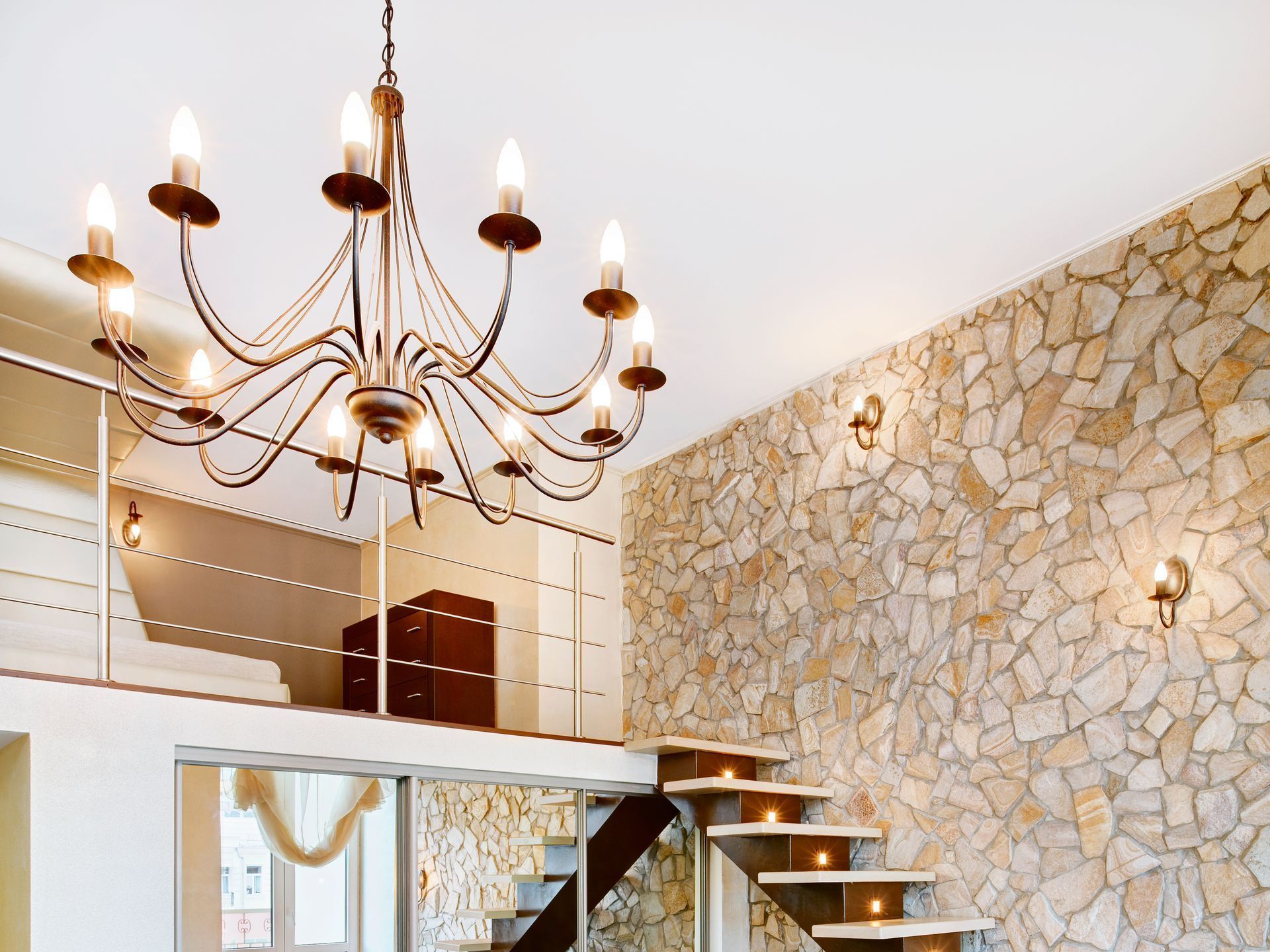 A chandelier is hanging from the ceiling above a staircase