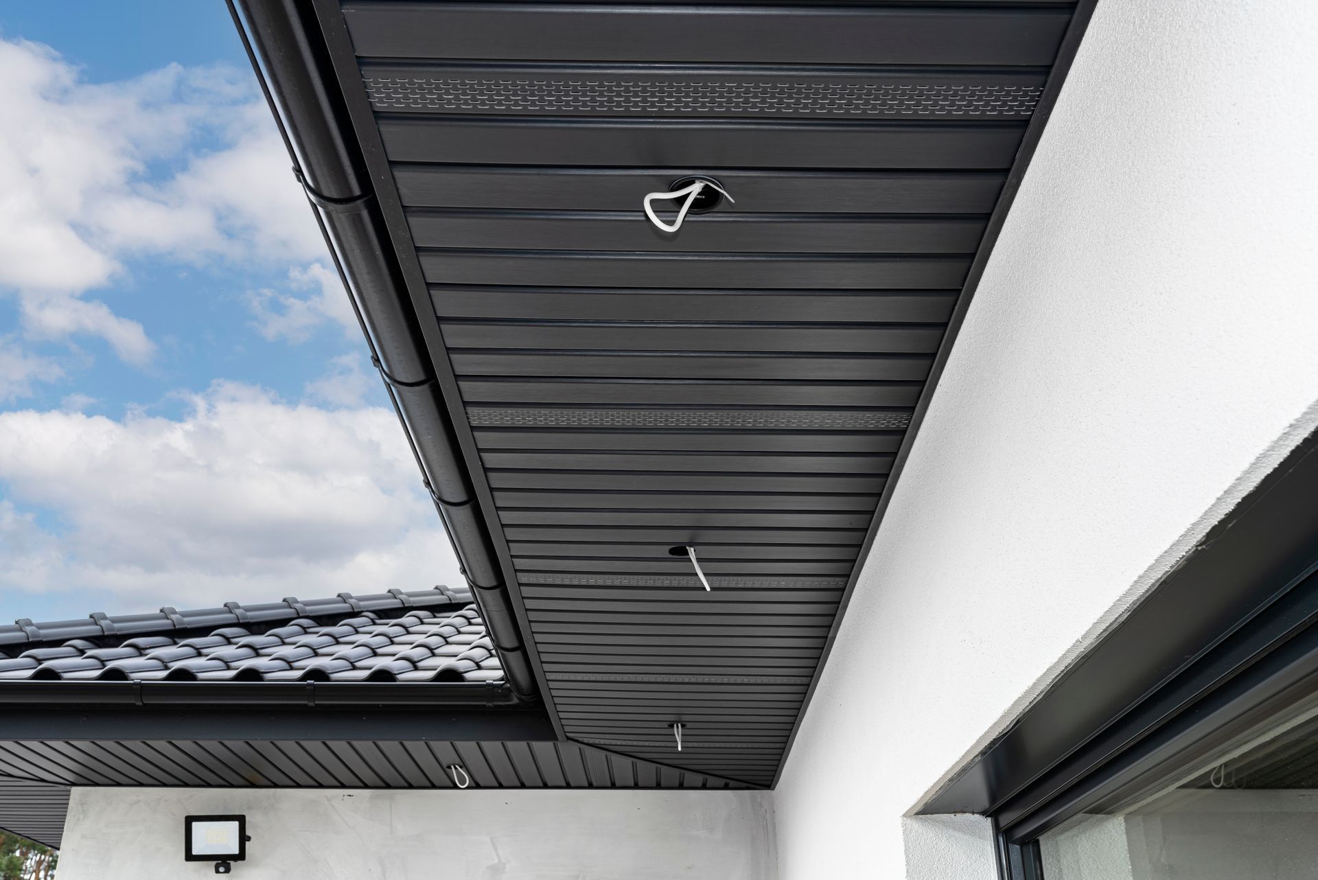 The ceiling of a house with a black roof and gutter.