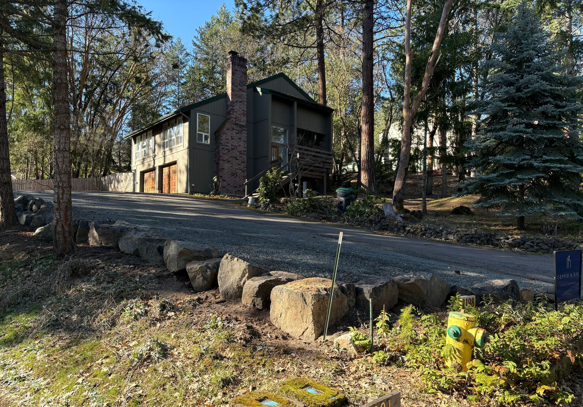 A gravel driveway with boulders lining the edge in front of a house in Ashland Oregon