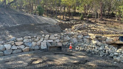 A winding driveway being constructed with a rock retaining wall in Ashland, Oregon