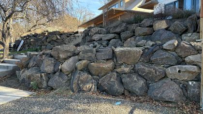 A multi tier boulder retaining wall in front of a house in Ashland, Oregon