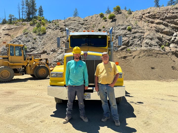 A yellow excavator and a yellow dump truck in Ashland, Oregon.