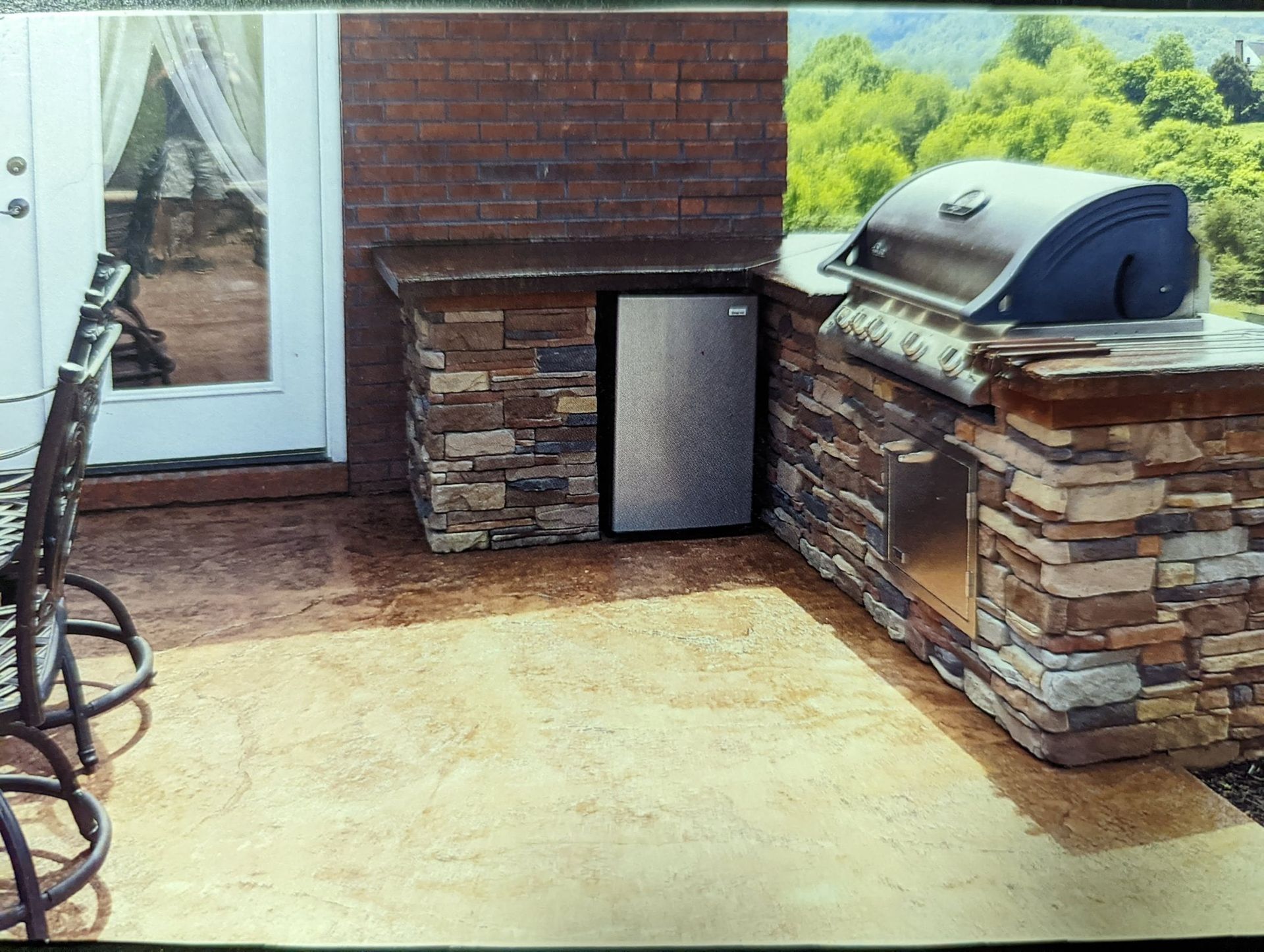 Patio with brick outdoor fireplace, built-in grill, and small stainless steel mini fridge near a sliding door