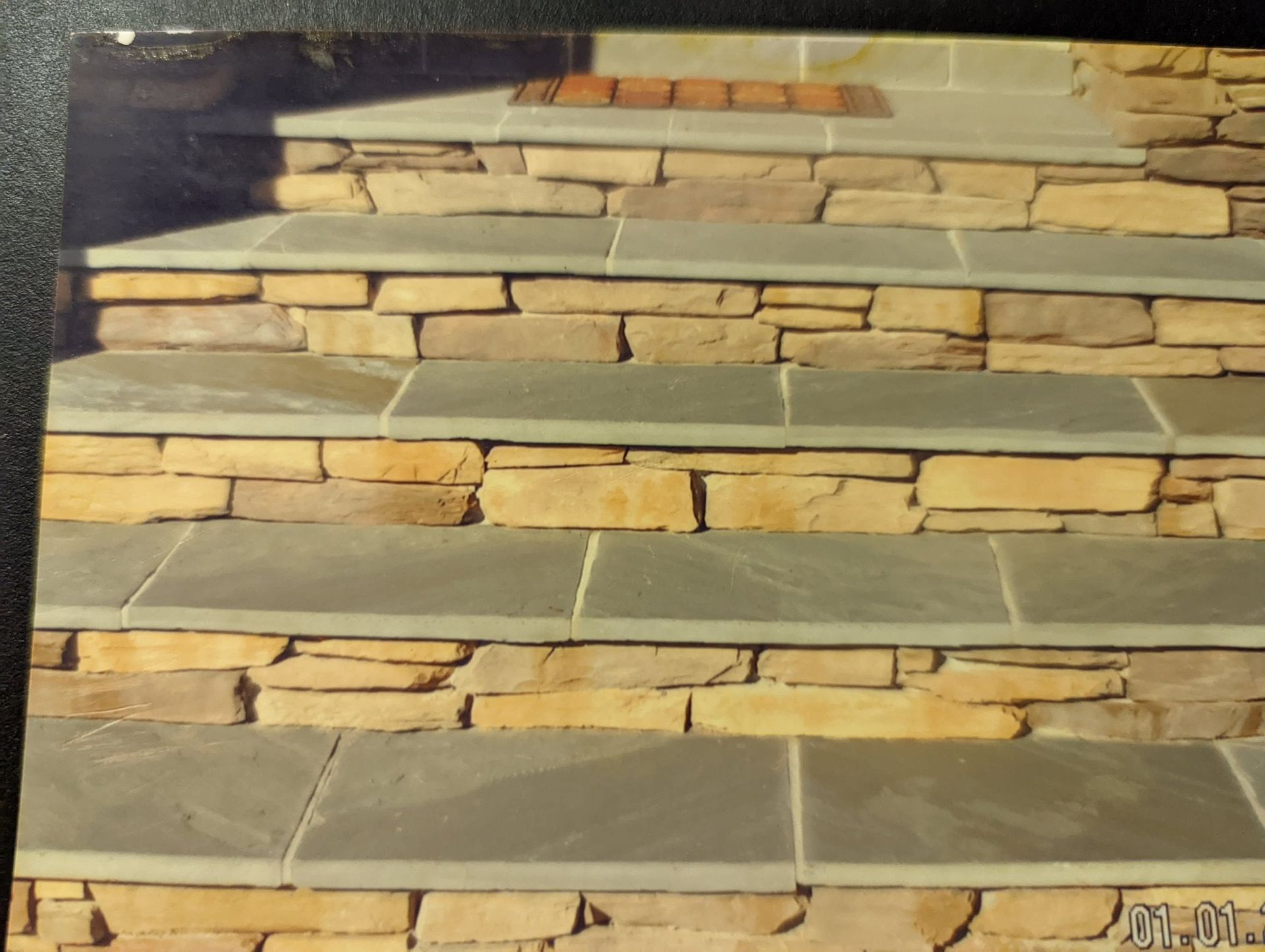Stacked beige and tan stone veneer tiles with visible mortar joints on a wall sample board