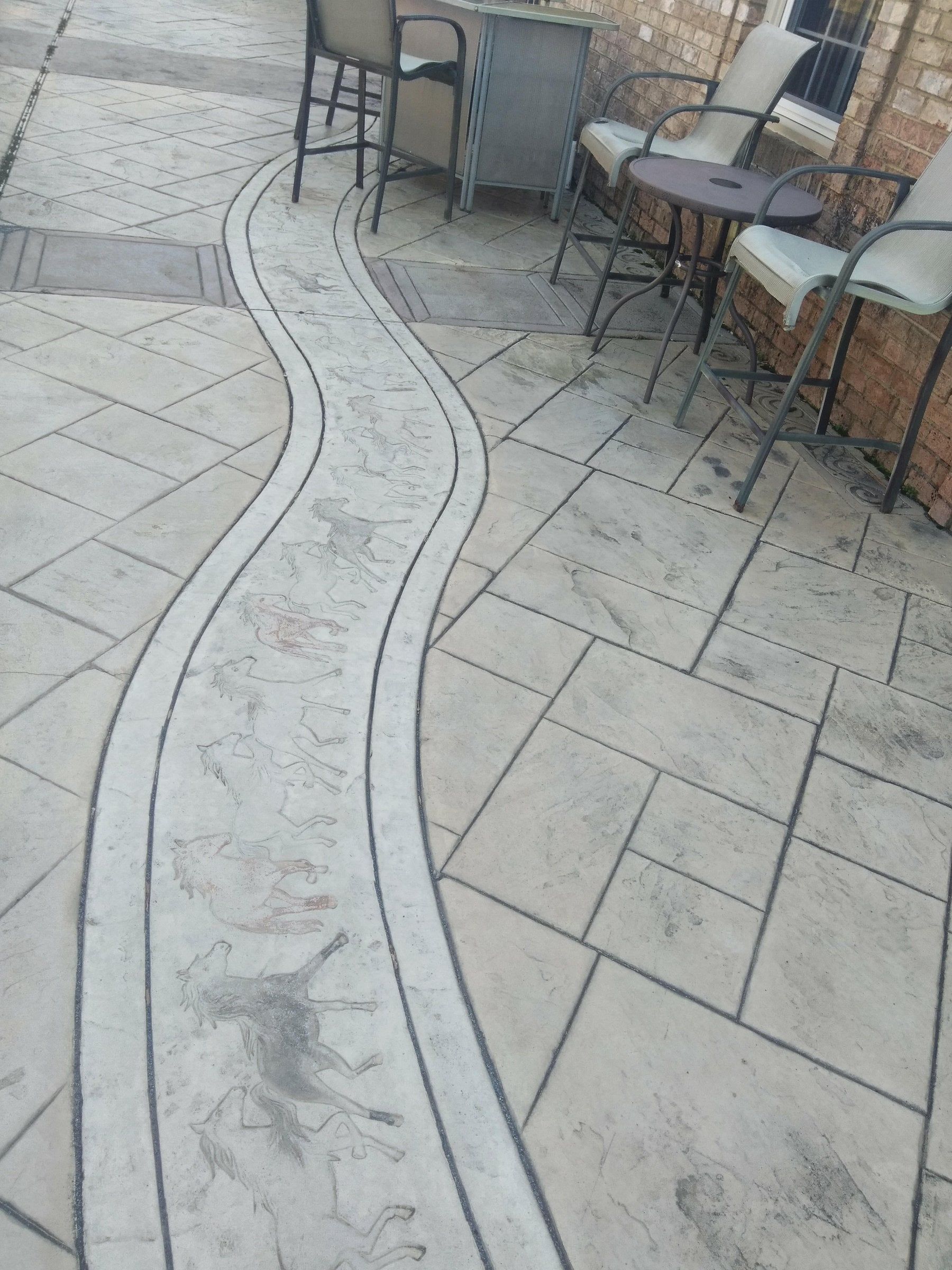 Outdoor patio with curved stone walkway between tables and chairs.