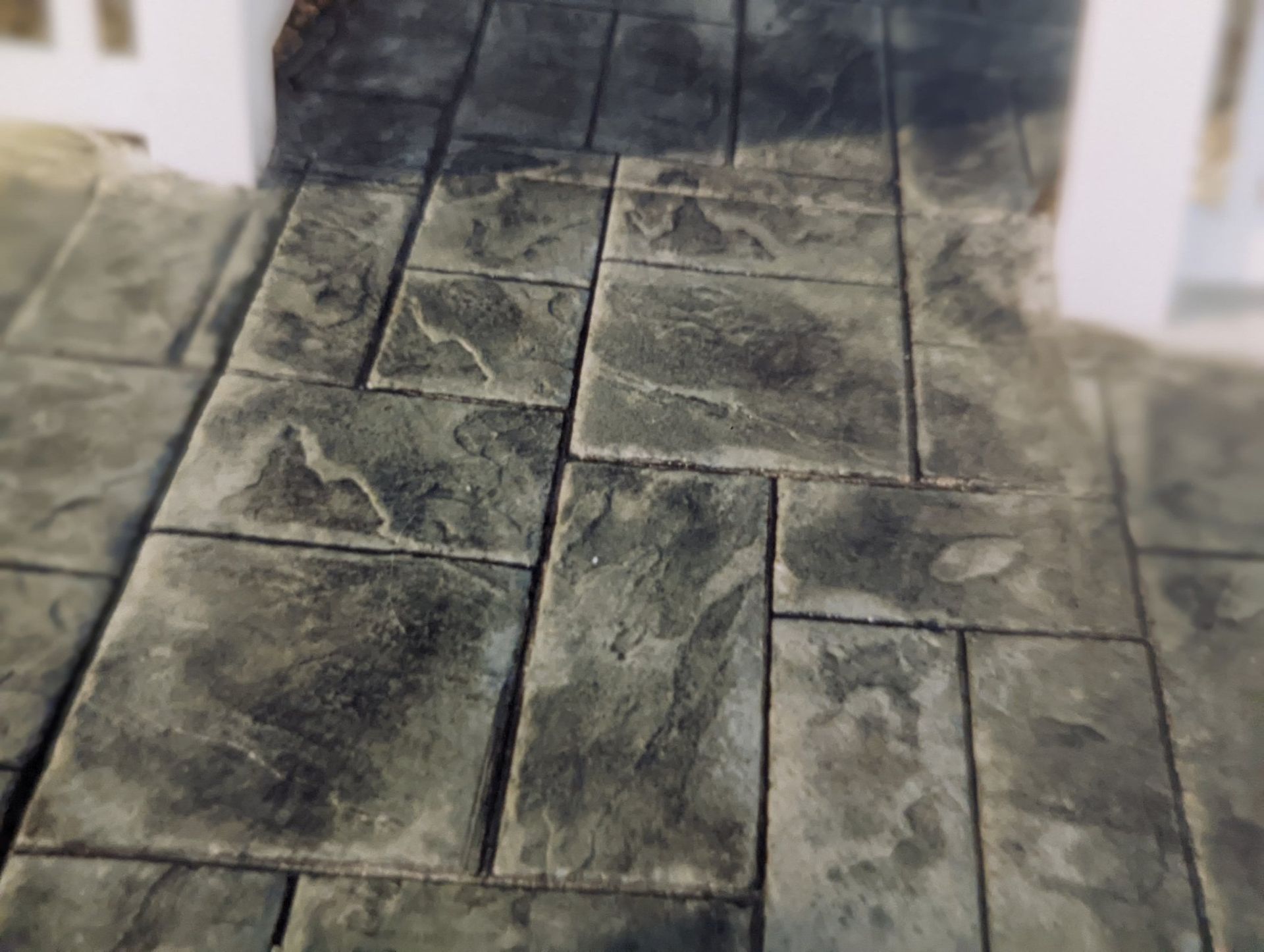 Patterned gray stone or tile flooring with rectangular slabs and dark grout lines