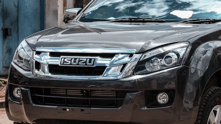 Close-up of a dark gray Isuzu D-Max truck's front grill and headlights. 