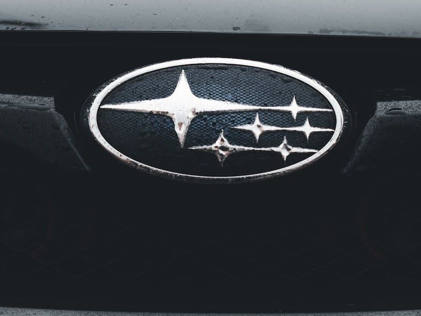 Subaru car logo: oval shape, silver outline, blue background with five stars.