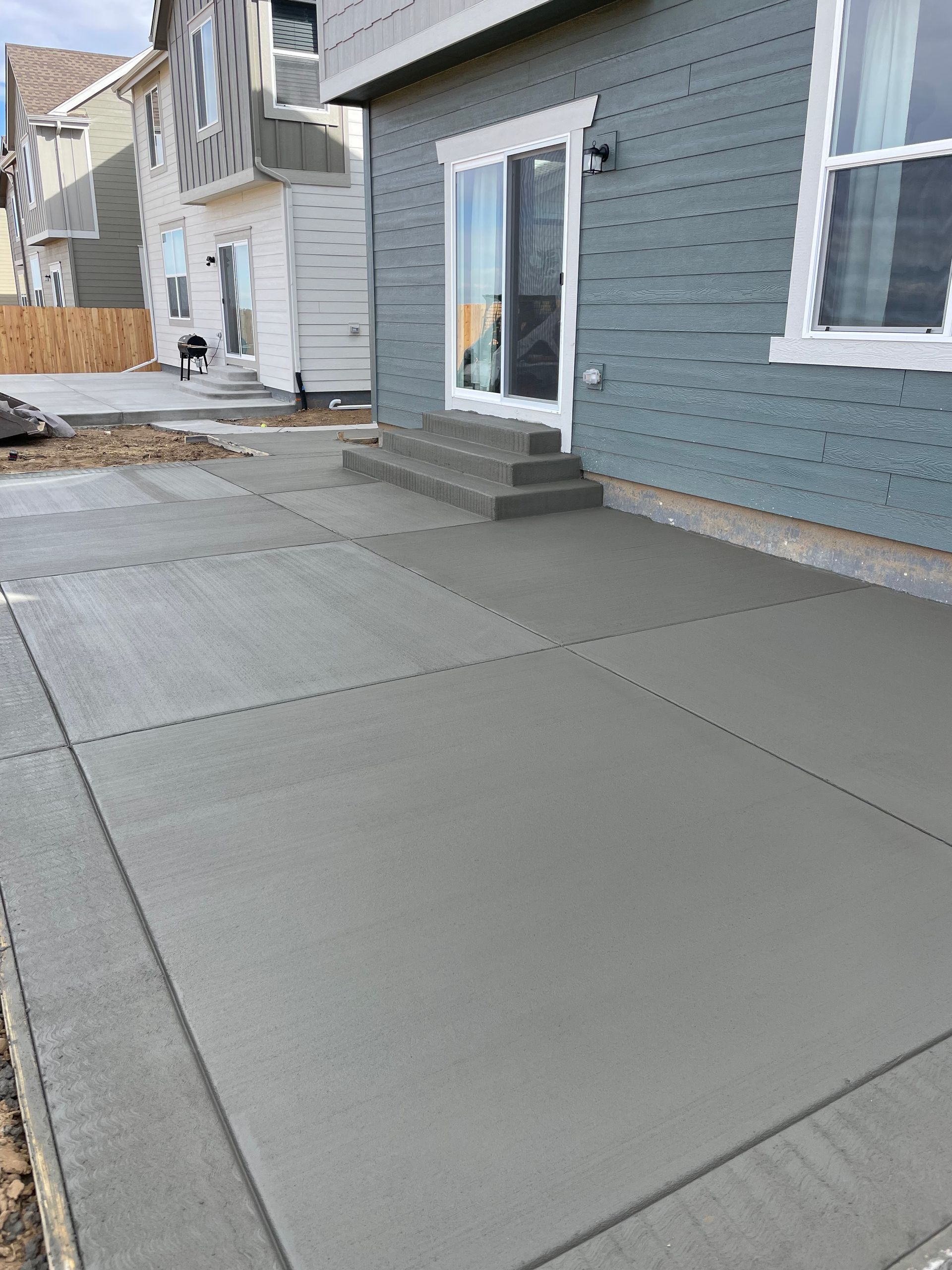 A concrete patio is being built in front of a house.