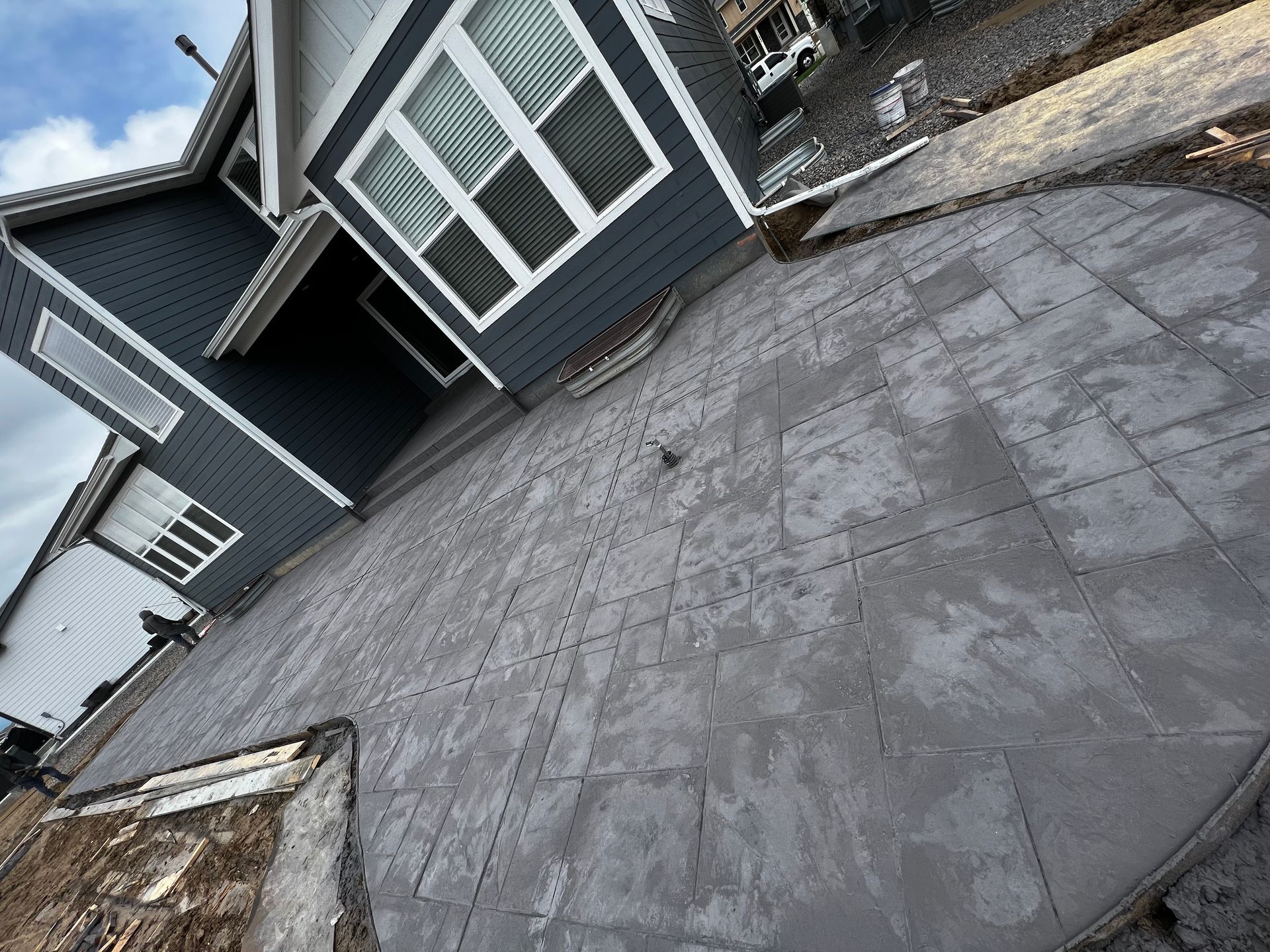 A patio is being built in front of a house.