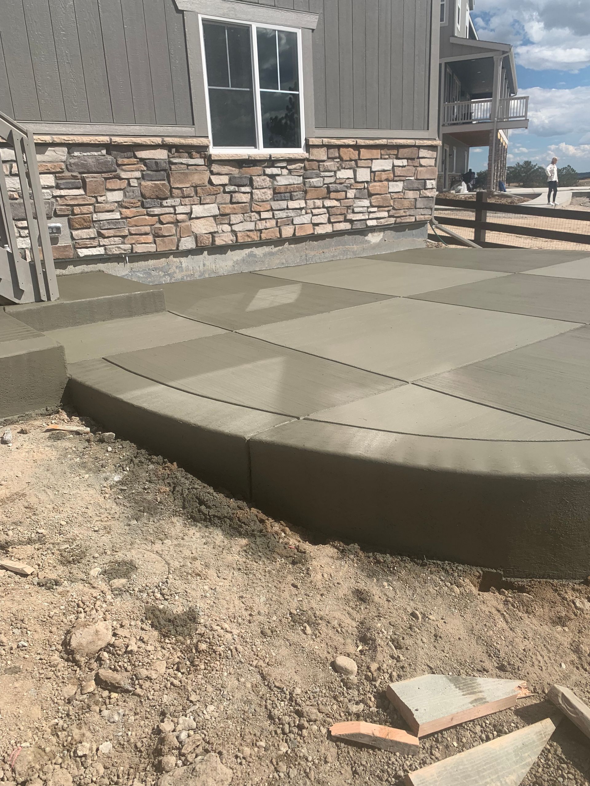 A concrete walkway is being built in front of a house.