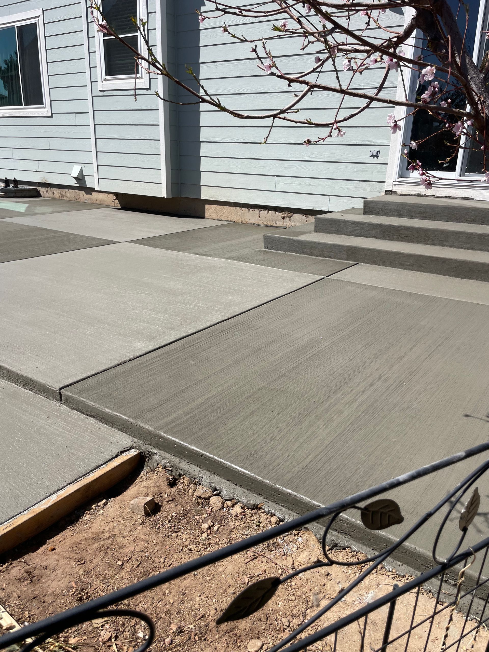 A concrete walkway is being built in front of a house