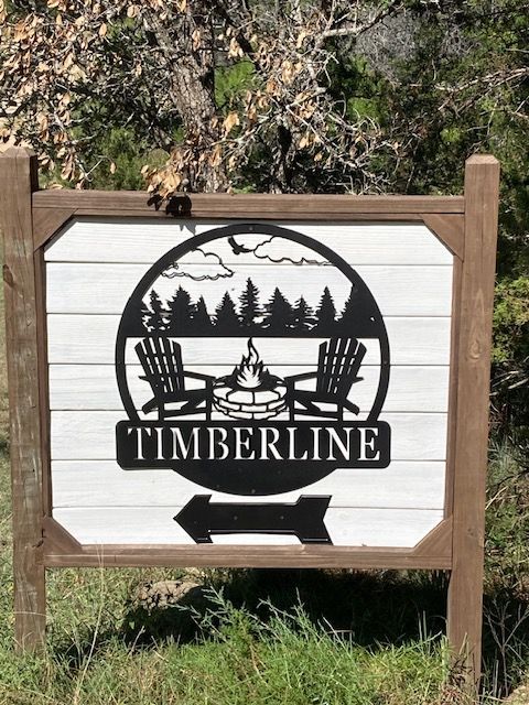 Timberline sign on a wooden post with a black logo and white panel outdoors
