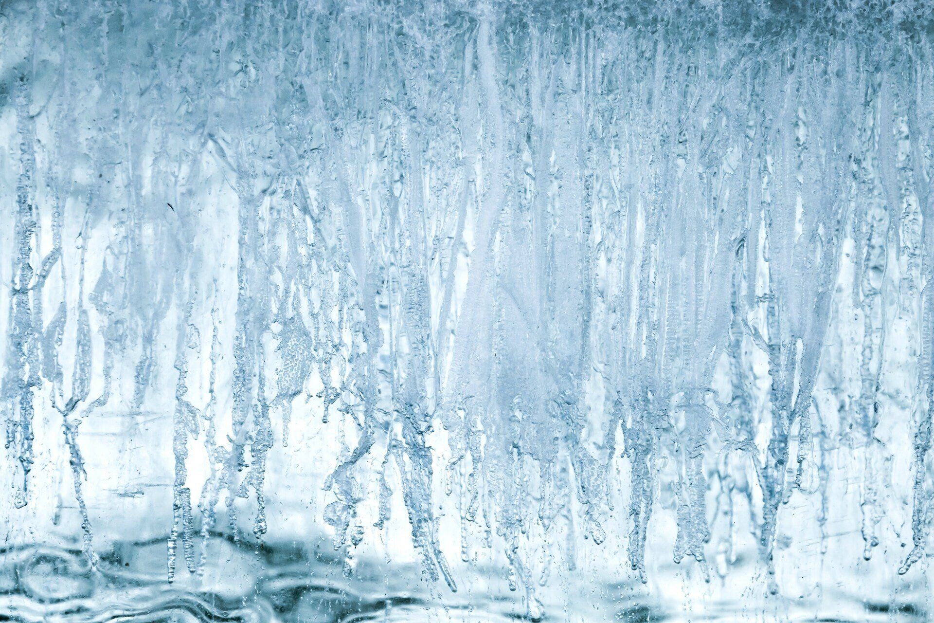 Close-up of translucent blue ice formation with drips and textured surface.